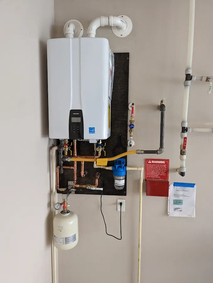 Professional plumber installing copper piping in a Minoa home